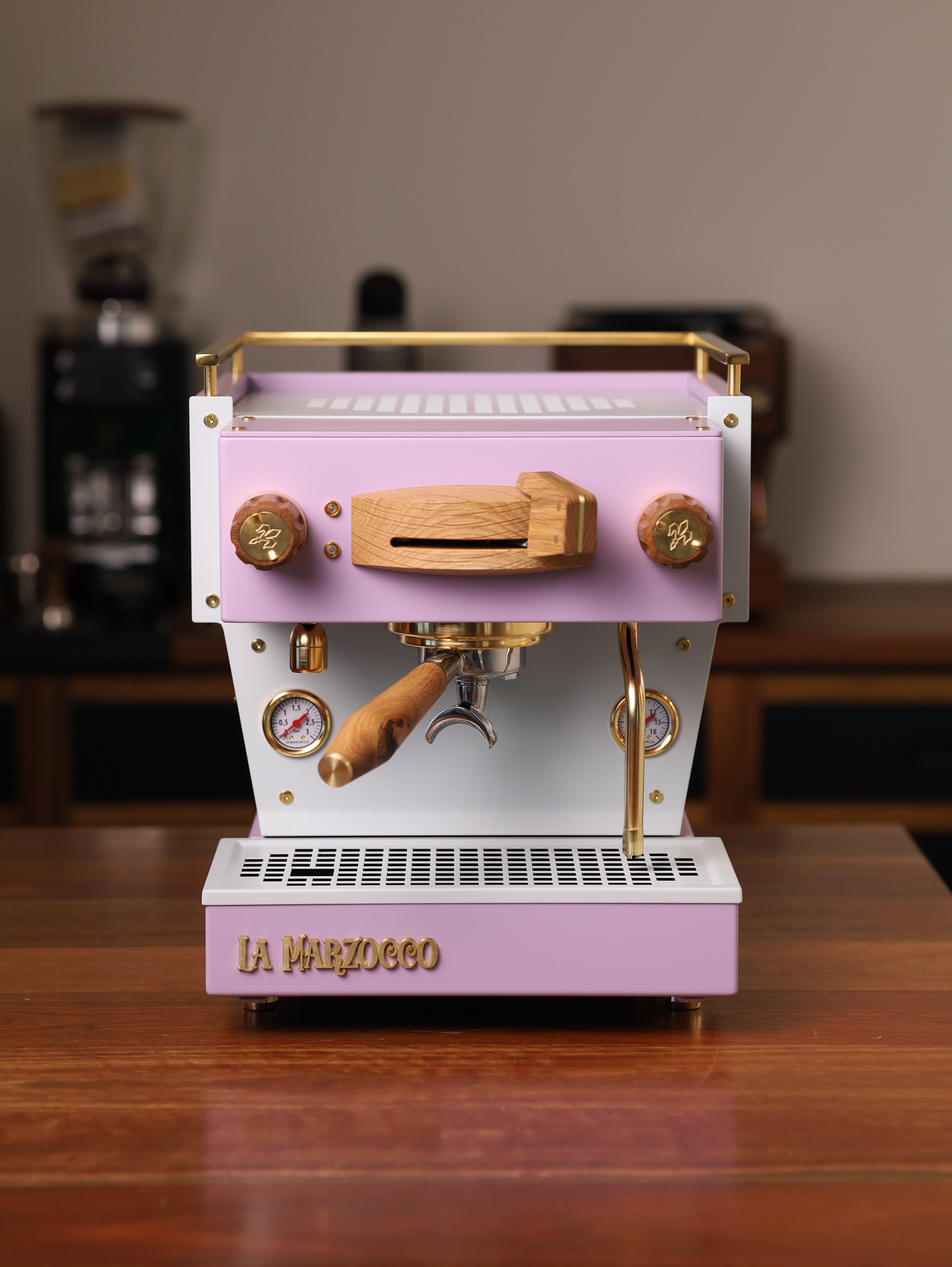 A bespoke, pink Linea Mini espresso machine with oak and brass-gold highlights, by Specht. We call it the Sugarplum.