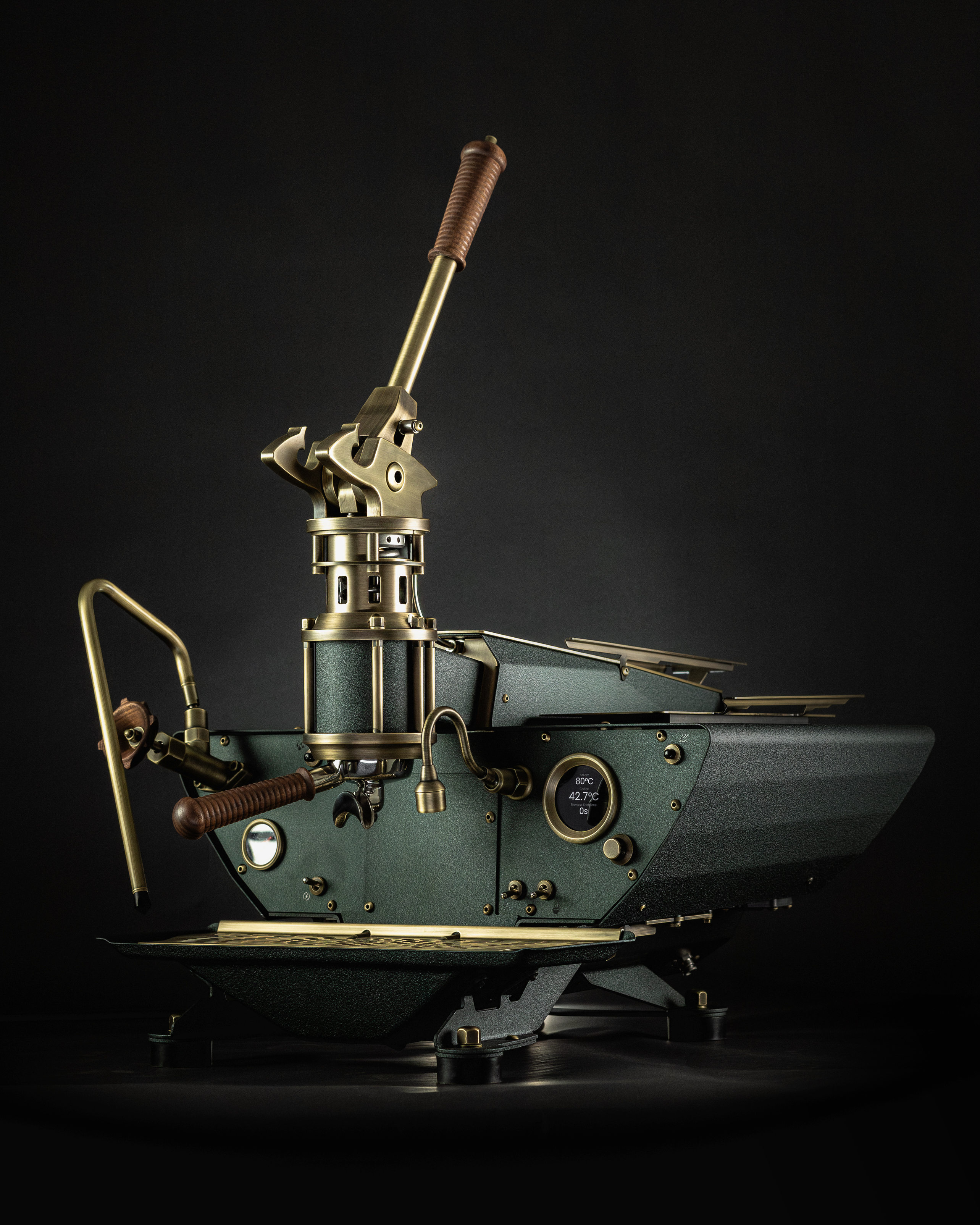 An emerald-green, luxurious Spiritello espresso machine by Specht with aged brass and walnut highlights. The tall lever has a ribbed, wooden handle.