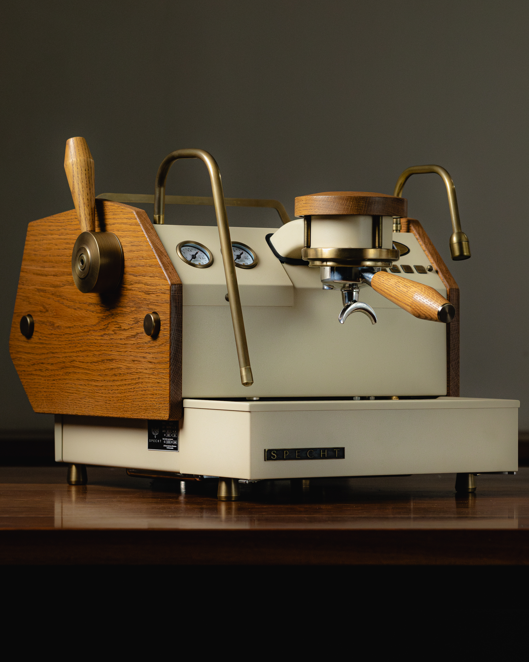 An almond-white La Marzocco GS3 AV espresso machine, redesigned by Specht with stained oak and aged brass accents.
