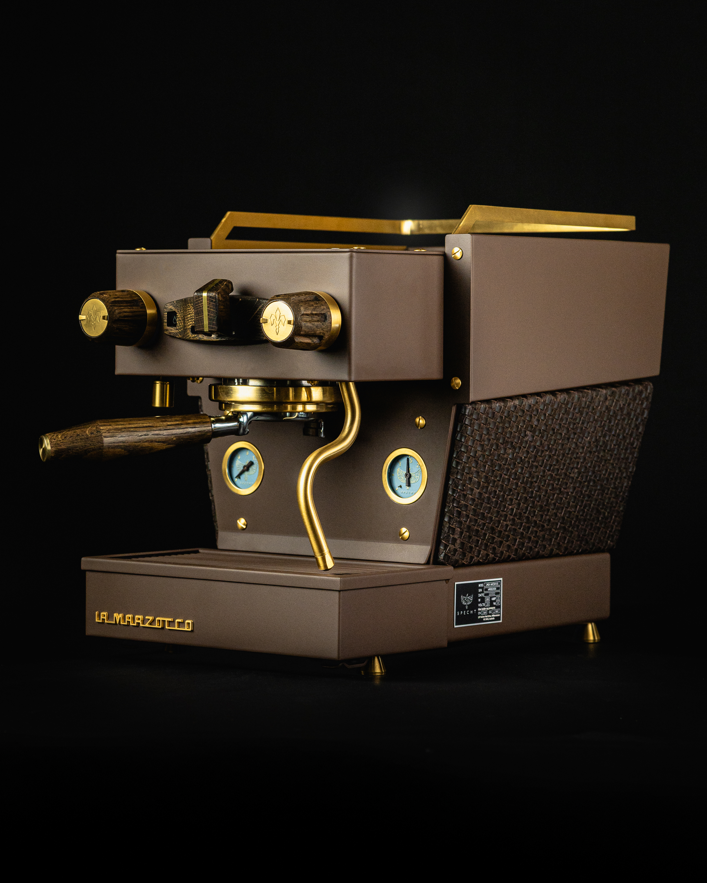 A bespoke brown Linea Micra home espresso machine, with gold highlights, aged oak touchpoints, and kangaroo-leather woven around its center, by Specht.