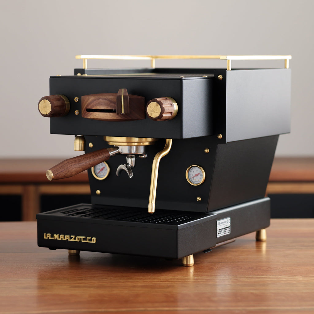 A black, Specht La Marzocco Linea Mini espresso machine with polished brass and walnut wood accents.