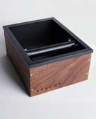 A wooden, walnut Specht knock box for coffee grounds disposal.