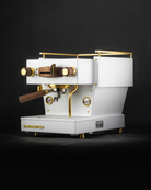 A white 2020 Linea Mini with walnut touchpoints and gold highlights, refurbished by Specht.
