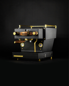 A bespoke black Linea Mini home espresso machine by Specht, with gold highlights and walnut touchpoints.