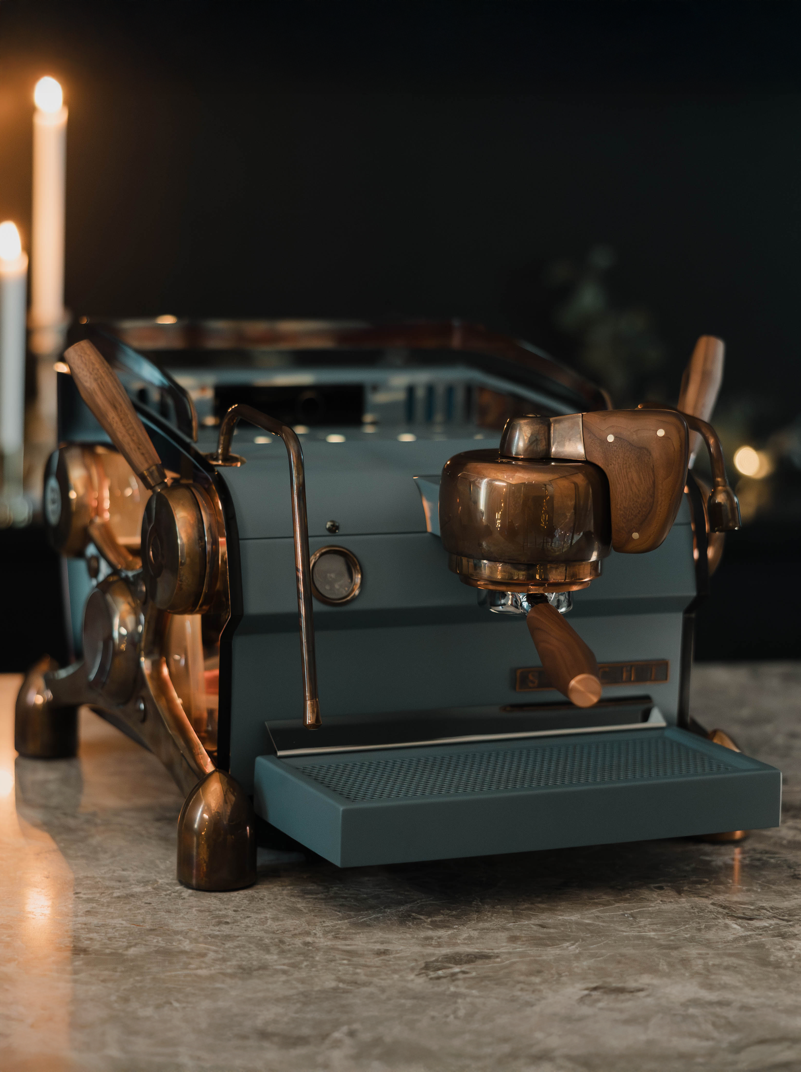 A deep blue, bespoke Slayer Single Group espresso machine with burnt copper highlights, walnut accents and backlit, smoked transparent side panels.