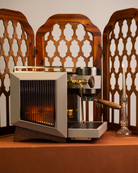 The amber-fluted, glass sides of a Rocket Bicocca home espresso machine, reimagined by Specht with pure 24-carat gold detailing and walnut touchpoints.