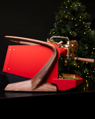 The sweeping walnut legs of a red, gold-plated Slayer Steam Single espresso machine, reimagined by Specht as Santa's Sleigher.