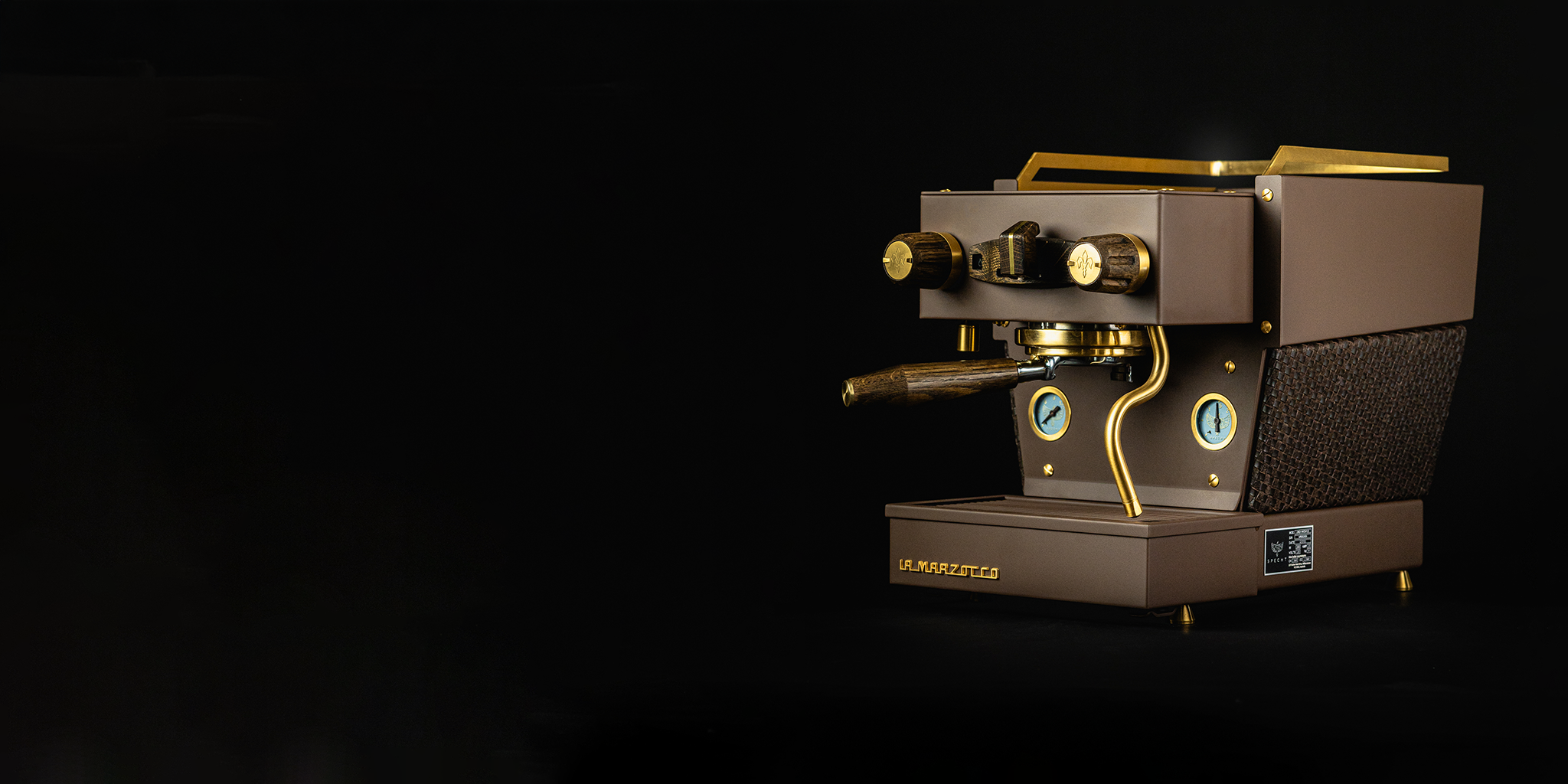 A bespoke brown Linea Micra home espresso machine, with gold highlights, aged oak touchpoints, and kangaroo-leather woven around its center, by Specht.