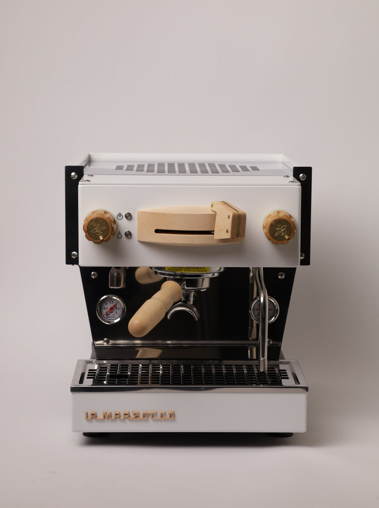 A front view of a white, La Marzocco Linea Mini espresso machine with a maple Specht wood kit.