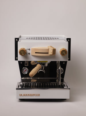 Open image in slideshow, A front view of a white, La Marzocco Linea Mini espresso machine with a maple Specht wood kit.
