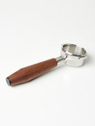 A bottomless Pesado portafilter with a Specht walnut, black end-capped handle.