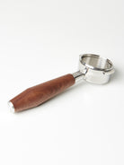 A bottomless Pesado portafilter with a Specht walnut, stainless steel end-capped handle.